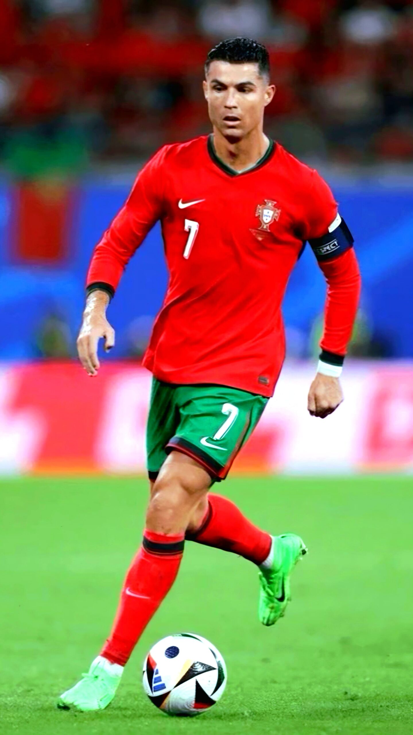 A soccer player in a red and green uniform with the number 7 dribbles a ball on a field during a match, as fans across the world tune in via IPTV Italy to catch the action live.