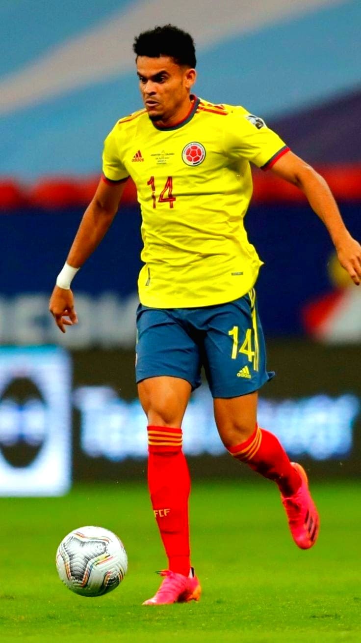 A soccer player in a yellow Colombia jersey with number 14 is running on the field, controlling a soccer ball, as fans stream the thrilling match live via IPTV Italy.