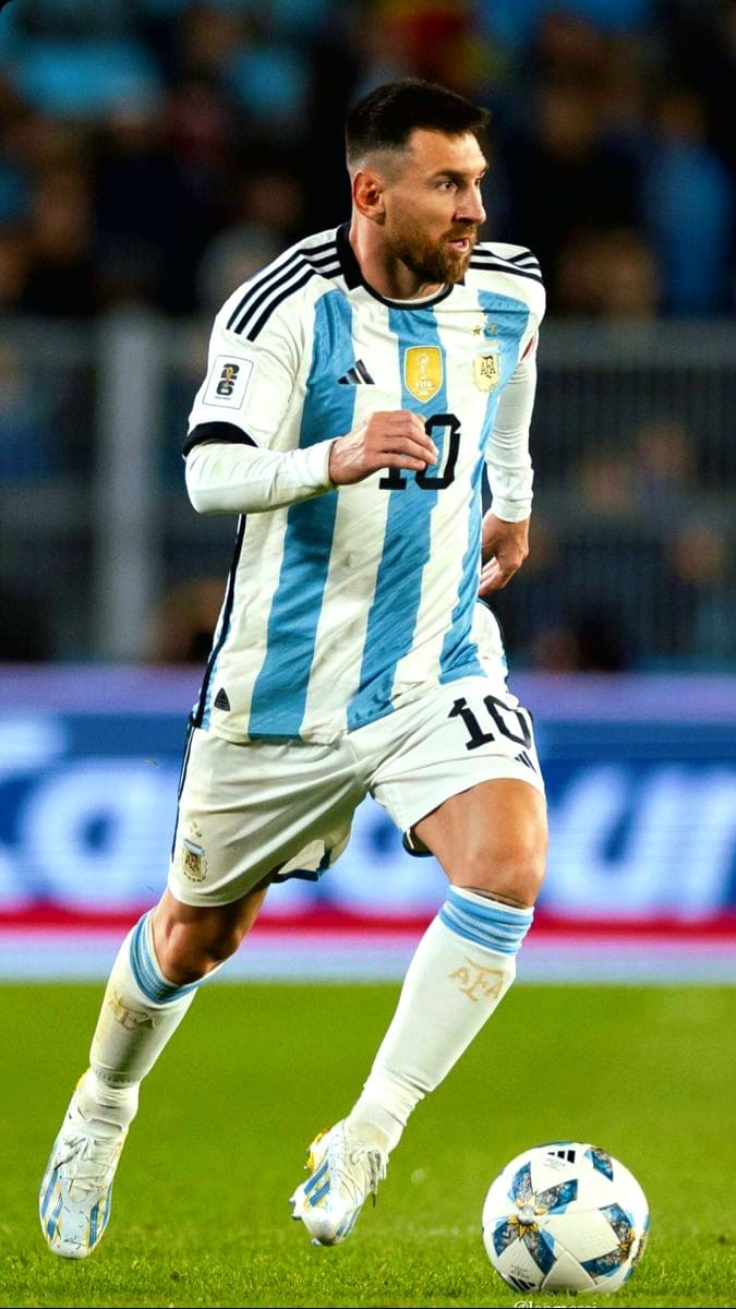 A soccer player in an Argentina jersey, number 10, runs on the field with a ball at his feet during a match streamed live on IPTV Italy. The background shows a blurred crowd and stadium lights.